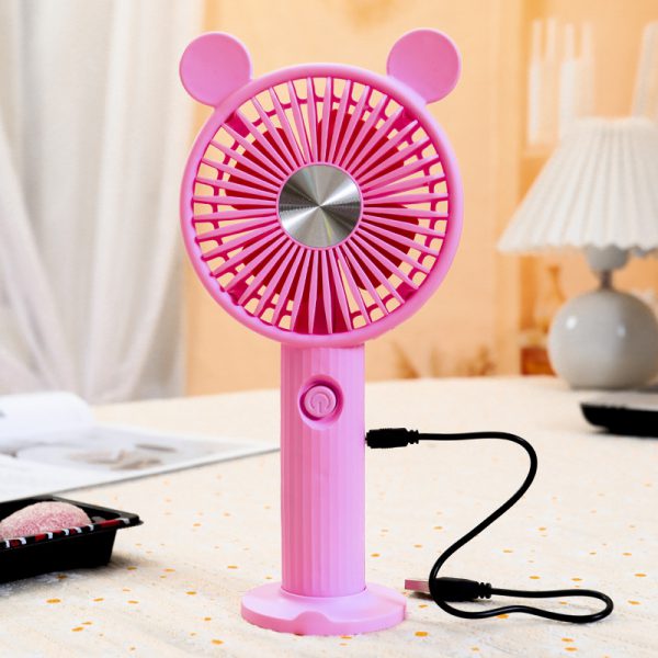 Pink round-ear mini fan on its desktop base connected to a USB charging cable