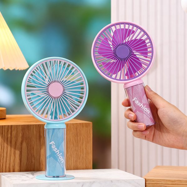 Pink fan held in one hand beside an Azure Blue fan on its circular desk base