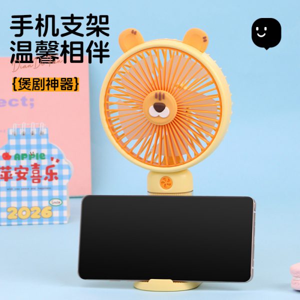 Yellow (Tiger) fan on its removable base with a phone resting in the front slot; phone not included