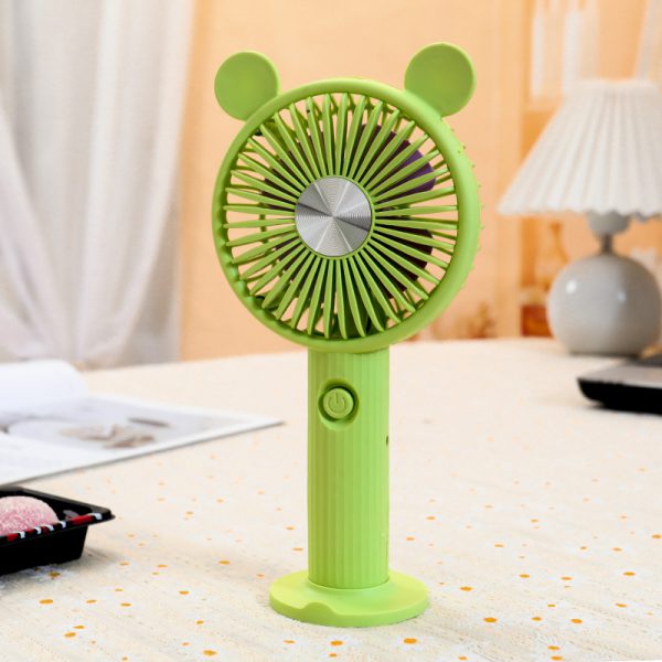 Green rechargeable handheld fan with round ears, ribbed handle and desktop base